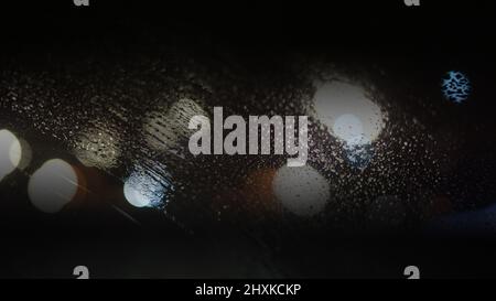 Blurred background with raindrops and lights. Stock Photo