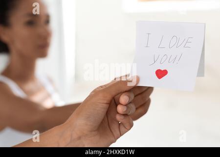 Woman Taking Off Sticky Note With I Love You Text On Mirror Stock Photo