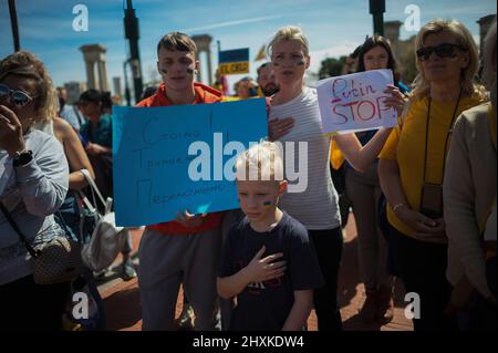 Protesters are seen listening to the Ukrainian anthem as they take part in an anti-war protest and in support of the Ukrainian people at Plaza de la Marina square. The community of expats living in Malaga has shown their support to Ukrainian people organizing a solidarity protest under the slogan: 'The united nations of Malaga stand by Ukraine'. Ukrainians continue protesting every week in Malaga against the Vladimir Putin government. Stock Photo