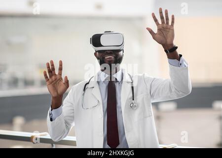 Excited african american doctor testing modern technologies in healtchare Stock Photo