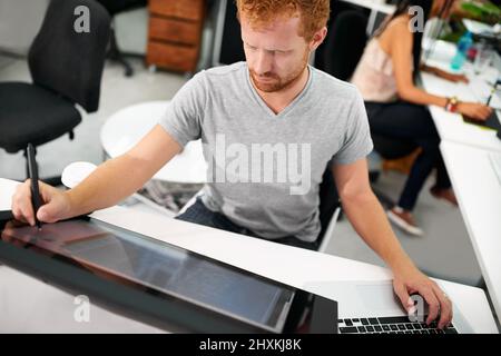 Smart technology makes everything easier. A young man working on a large touchscreen. Stock Photo