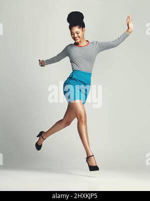 Chase your dreams in high heels of course. Studio shot of a fashionable young woman posing against a grey background. Stock Photo