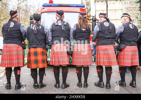 London, UK. 13th Mar, 2022. The Fire Brigade Union pose for a cheeky photo in their kilts. Participants and spectators have fun at the Mayor of London's St Patrick's Day parade through central London with marching bands, dancers and pageantry, despite the weather. There are also a with stage, stalls and performances on Trafalgar Square. Credit: Imageplotter/Alamy Live News Stock Photo