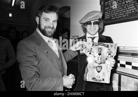 Musician and Watford FC chairman Elton John is presented with a special Jubilee plaque presented to him by West Bromwich Albion fan, Ray Egan. This was some consolation for Elton after the 1-0 defeat by Albion in the Football League Cup clash at The Hawthorns. 25th October 1977. Stock Photo