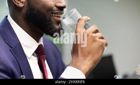Unrecognizable black businessman drinking water, copy space Stock Photo