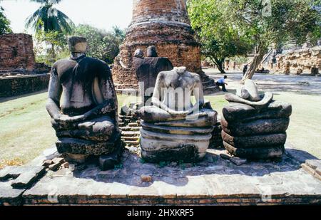 Three beheaded Buddha statues at Wat Phra Si Sanphet temple in Ayutthaya. The former capital of Siam was conquered by a Birmese army in 1767 and afterwards ransacked and partly destroyed. There still is a sense of the former splendour of the great temple. Stock Photo