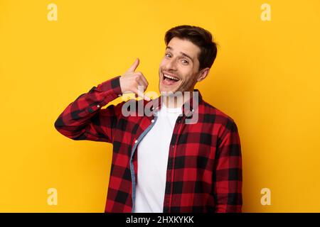 Portrait of smiling man making call me gesture Stock Photo