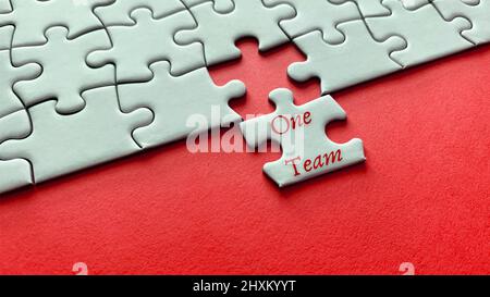 Motivational and inspirational quote on missing jigsaw puzzle - One Team. Team work concept concept Stock Photo