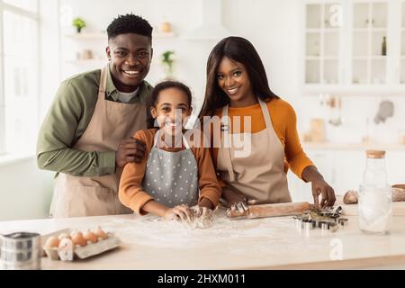 Happy Smiling African Family In Aprons Cooking And Kneading Dough On Wooden  Table Stock Photo - Download Image Now - iStock