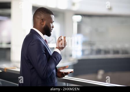 Rear view of young black manager drinking coffee Stock Photo