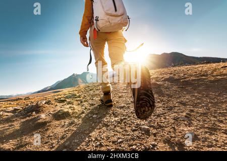 Female hiker walks in mountains. Close up photo of legs Stock Photo