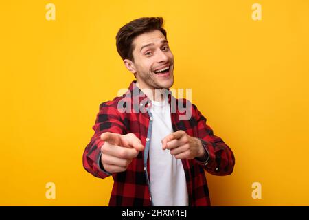 Happy young man pointing fingers at camera at studio Stock Photo
