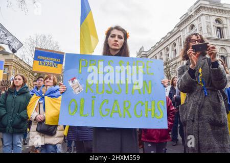 London, England, UK. 13th Mar, 2022. A woman holds a placard which reads 'Pressure Russian Oligarchs'. Thousands of people gathered outside Downing Street for the 19th consecutive day of protests in support of Ukraine as Russia continues its attack. (Credit Image: © Vuk Valcic/ZUMA Press Wire) Stock Photo