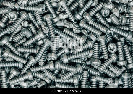 A huge arrenge of taping metal or iron screws, screws as a background, wallpaper or texture, industrial background and concept Stock Photo
