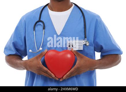 Hell take care of your cardiological needs. Cropped image of an african doctor holding a heart prop. Stock Photo