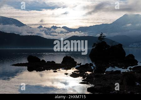 afternoon sun seen from Seewiese with fog rising from lake and Sarstein mountain in background Stock Photo