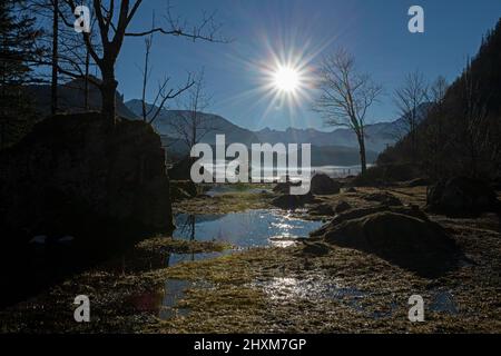 afternoon sun seen from Seewiese with fog rising from lake and Sarstein mountain in background Stock Photo