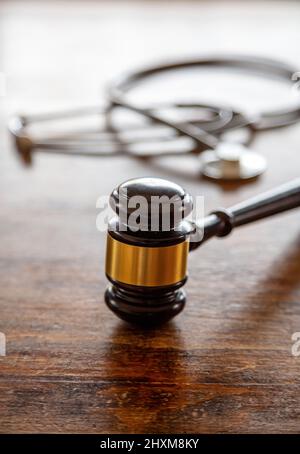 Personal injury attorney. Judge gavel and doctor stethoscope on lawyer office desk. Health and Law concept. Medical malpractice, legal aspects Stock Photo