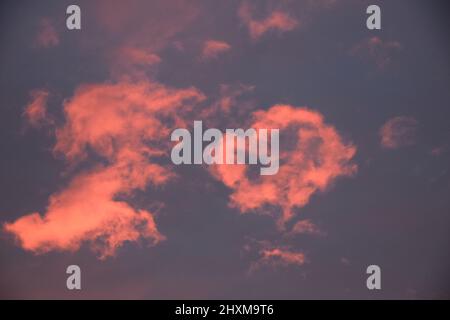 Shapes and patterns in the clouds set ablaze by the setting sun. Stock Photo