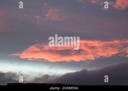 Shapes and patterns in the clouds set ablaze by the setting sun. Stock Photo