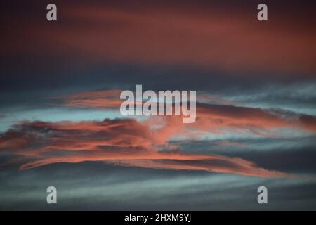 Shapes and patterns in the clouds set ablaze by the setting sun. Stock Photo