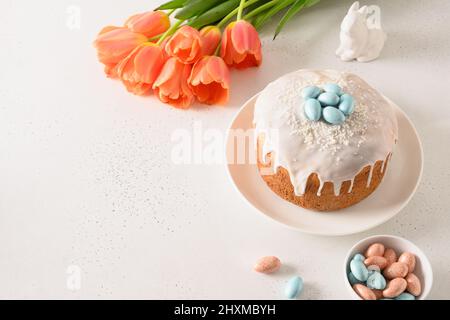 Composition with Easter cake, rabbit and chocolate eggs, spring tulips. Christian custom. Copy space. Festive morning. Stock Photo