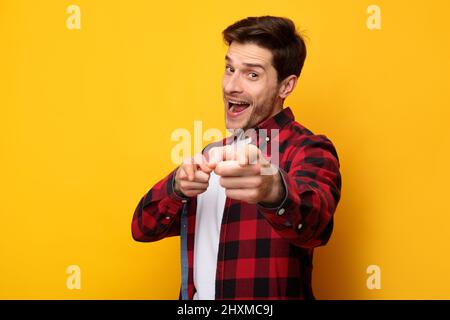 Happy young man pointing fingers at camera at studio Stock Photo