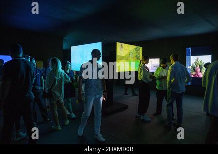 DUBAI, UAE, 13th March 2022. Visitors view NFT displays at the Dubai WOW (World of Web3) Summit. This event is a leading gathering of senior decision-makers discussing the impact of blockchain and associated technologies on financial services Stock Photo
