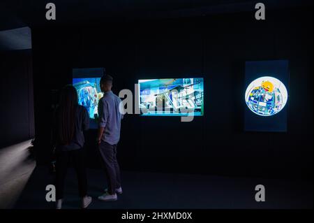 DUBAI, UAE, 13th March 2022. Visitors view NFT artwork at the Dubai WOW (World of Web3) Summit. This event is a leading gathering of senior decision-makers discussing the impact of blockchain and associated technologies on financial services Stock Photo