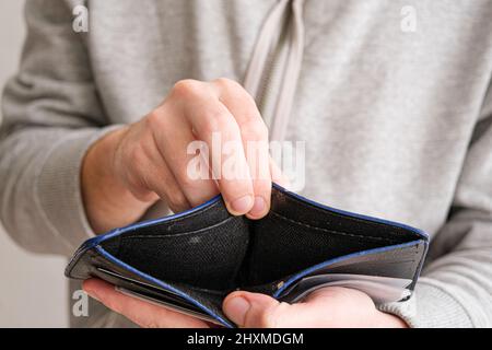 Man hand showing an open empty wallet close up. Poverty, cost control expenses, spent too much, not enough cash, lost money concept idea. Top above. Stock Photo