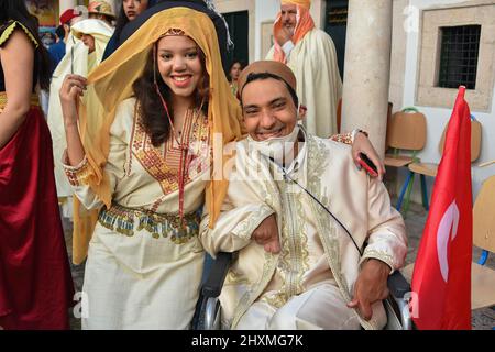 Tunis, Tunisia. 13th Mar, 2022. A couple wearing traditional clothing takes part in a march during the National Day of Traditional Dress' organized by Tunisia Heritage Association in Tunis. Every year in March, Tunisians commemorate their history by wearing their traditional dress to ensure that their past is not forgotten. This year participants began the march from Madrasa Slimania towards the Statue of Ibn Khaldun. Credit: SOPA Images Limited/Alamy Live News Stock Photo