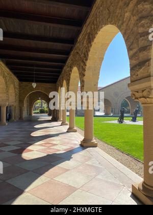 These are the archways surrounding the courtyard at Stanford University in Stanford, California. It is near Rodin sculptures, Gates of Hell,by grass. Stock Photo