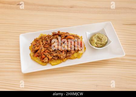 toast made with plantain, with smooth guacamole and shredded meat Stock Photo