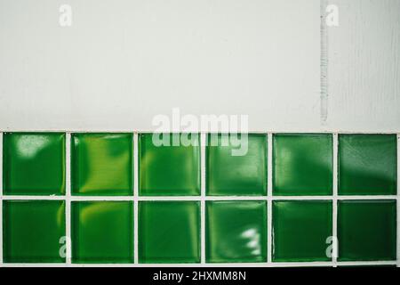 Bright green with white grout retro tile backsplash under aged wood background Stock Photo