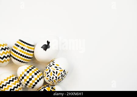 Happy Easter concept. Preparation for the holiday. Easter eggs with patterns of stripes, zigzags, dots and rabbits on white background. Simple minimal Stock Photo
