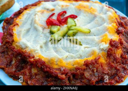 Kolocheni Fasoli or ukrainian mashed potatoes with onion and garlic with pickles on top Stock Photo