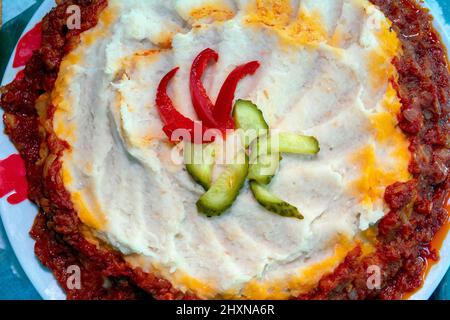 Kolocheni Fasoli or ukrainian mashed potatoes with onion and garlic with pickles on top Stock Photo