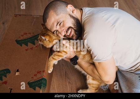 Man lovingly embracing purebred cat. True friendship between man and animal. Beautiful man embracing cat, great design for any purposes. Animal lover Stock Photo