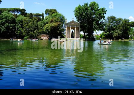 People enjoying Laghetto di Villa Borghese with the Temple of Aesculapius set on an island on the lake in Rome Italy Stock Photo