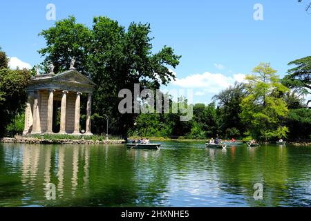 People enjoying Laghetto di Villa Borghese with the Temple of Aesculapius set on an island on the lake in Rome Italy Stock Photo