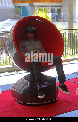 Hollywood, CA / USA - May 20, 2017: A man wears a 3D headset while sitting in a Positron Voyager VR chair. Stock Photo