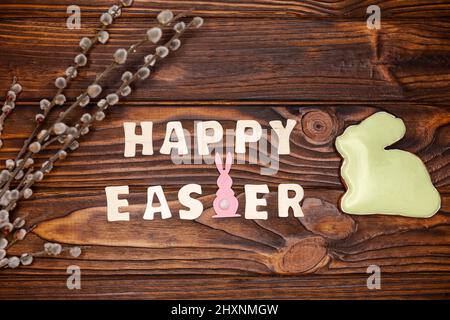 Beautiful glazed Easter cookies and willow on dark brown wooden table. Stock Photo