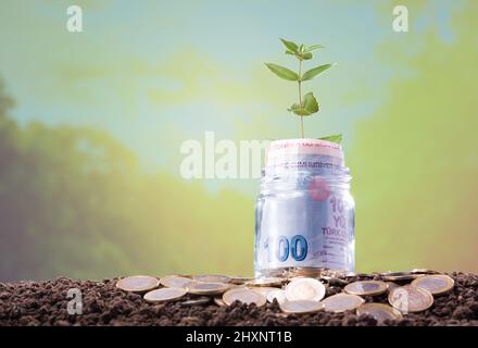 Turkish banknotes in a glass jar. Turkish Coins on the ground. Investment and Finance Concept Stock Photo