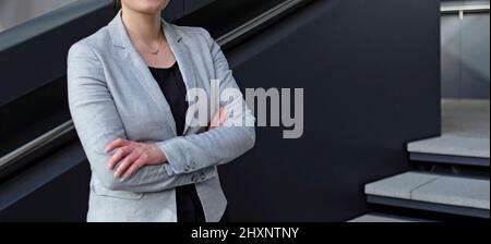 Female professional in a black shirt and grey suit jacket Stock Photo