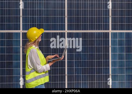 Woman engineer checking the solar panels with the computer Stock Photo