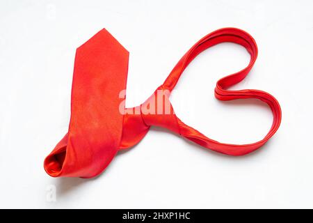 Heart shape folded red necktie isolated on a neutral background. Creative Valentine's Day outfit concept. Stock Photo