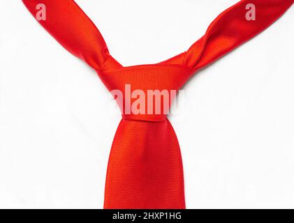 Tied red necktie knot close-up isolated on white. Stock Photo