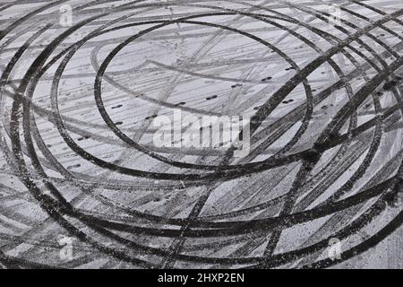 Car drift skid marks abstract background, circles in snow on winter road race track. Stock Photo