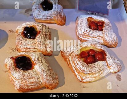 Assorted bakery bun and butter pastry displayed on retail shelf- Danish roll, Japanese Melon pan, baguette, croissants and bread loaf Stock Photo