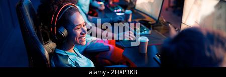 Professional woman gamer participates in team play in cyber club Stock Photo